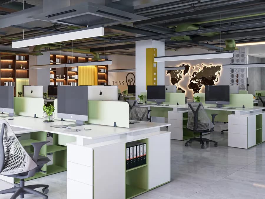 Modern office workstation cluster with green accent panels and acoustic ceiling panels