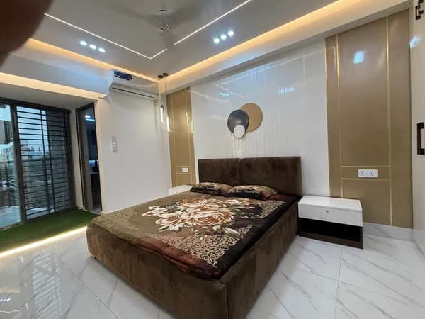 Master bedroom interior design with stone headboard wall and LED cove lighting in Khulna apartment